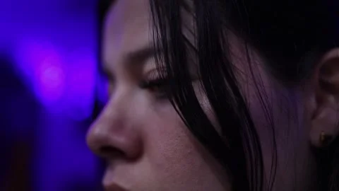 Close-up of Woman's Face with Dramatic Purple Lighting and Soft Bokeh Stock Footage 338041681