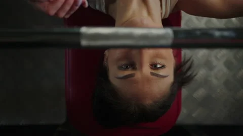 Close-up of a woman's face during a bench press. Heavy training in the gym Stock Footage 197017236