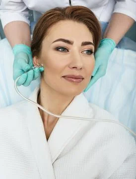 Close-up of a woman's face during ozone therapy procedure. Beautician treats  库存照片