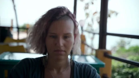 Close-up of a woman's face focused on working at a laptop in a cafe Video stock 234021174