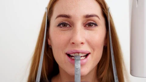 Close-up of woman's face with head positioned in cephalometric panorama x-ray Stock Footage 261988716