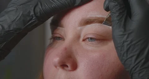Close-up of a womans face. The procedure for coloring and shaping eyebrows Stock Footage 311161039