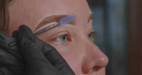 Close-up of a womans face. The procedure for coloring and shaping eyebrows Stock Footage 311161085