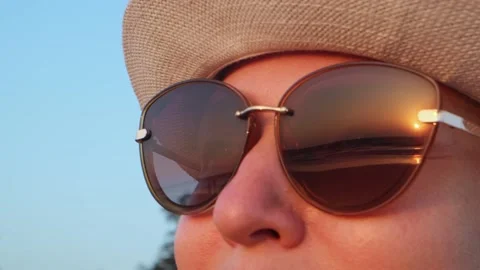 Close-up of a woman's face, she is admiring the sunset on the sea. Видео 237601332