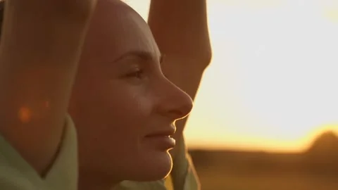 Close-up of a woman's face at sunset relaxing, breathing in fresh air, doing Stockbeeldmateriaal 213248030