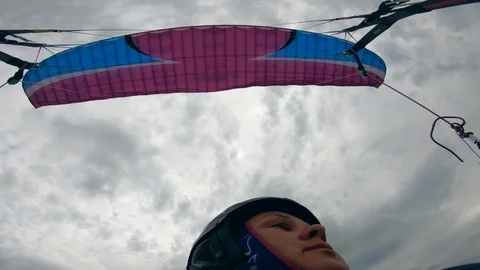 Close up of woman's face while flying the paraglider 動画素材 113470311