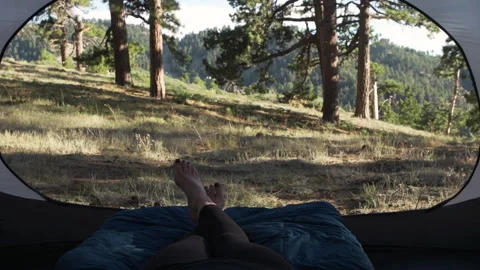 Close-up of a woman's feet crossing while relaxing in her tent Stock Footage 138475336