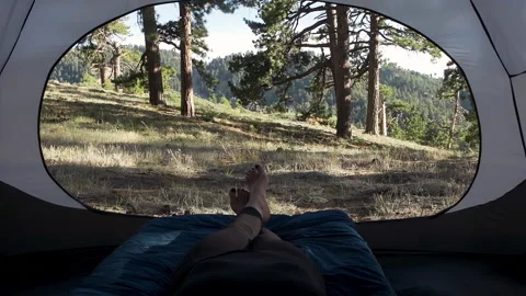 Close-up of a woman's feet crossing while relaxing in her tent Stock Footage 138475539