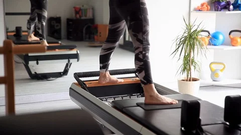 Close up of a womans feet doing refomer pilates Stock Footage 107136673