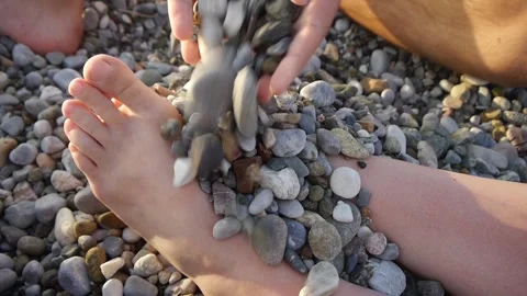 Close-up of woman's feet on a pebble beach Stock Footage 265173779