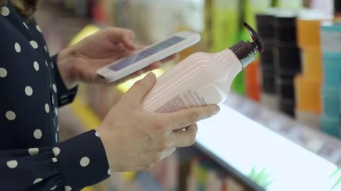 Close-up of a woman's gloved hands scans the composition of a body cream with a Stock-Footage 155297411