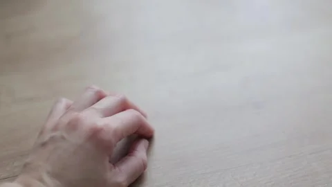 A close up of a womans hand from above, nervously tapping her fingers on a Stock Footage 266898517