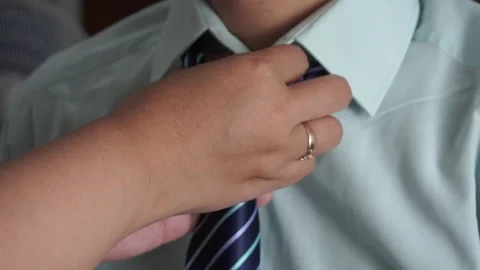 Close up of a woman's hand adjusting and fixing a blue striped necktie on a man Video stock 337760910