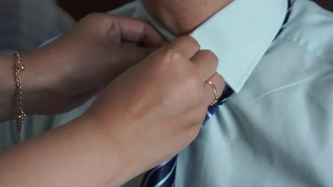 Close up of a woman's hand adjusting and fixing a blue striped necktie on a man Stock-Footage 337760948