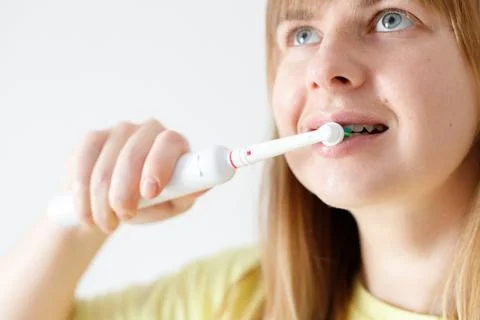 Close-up Of A Woman's Hand Brushing Teeth With Electric Toothbrush Foto stock