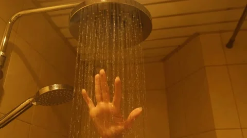 Close-up of woman's hand checking the temperature of the water in the shower Stock Footage 131591650