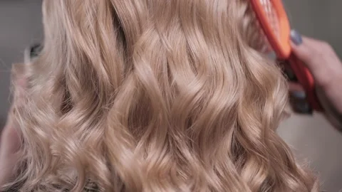 Close-up of a woman's hand combing the waves on the blonde's head. Stock Footage 148567172