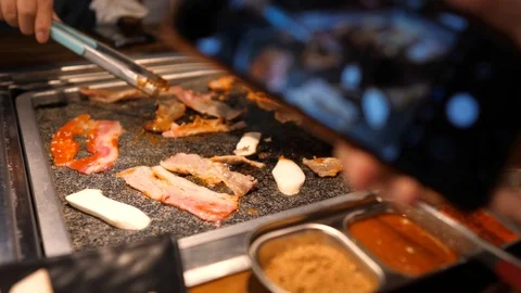 Close-up of woman's hand coocking korean barbecue in a restaurant Video stock 122441944