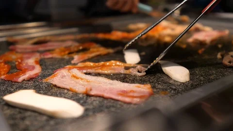 Close-up of woman's hand coocking korean barbecue in a restaurant Video stock 122441962