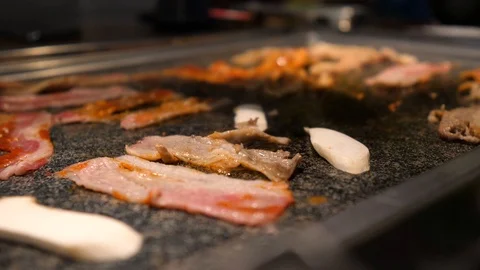Close-up of woman's hand coocking korean barbecue in a restaurant Video stock 122441975