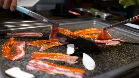 Close-up of woman's hand coocking korean barbecue in a restaurant Video stock 122446394