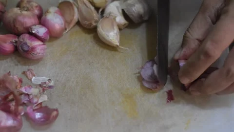 A close-up of a woman's hand cutting an onion on a white cutting mat Stock Footage 287997106