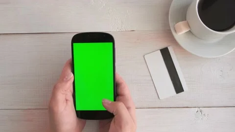 Close-up of a woman's hand drinking coffee and using a green-screen phone Stock Footage 170367751