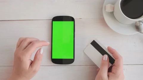 Close-up of a woman's hand drinking coffee and using a green-screen phone Stock Footage 172090995