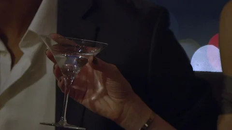 Close Up of a woman's hand elegantly holding a martini glass Stock Footage 117066061