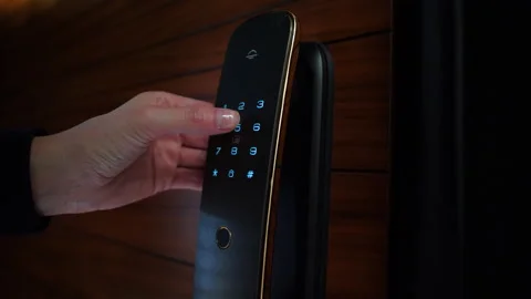 Close-Up of a Woman's Hand Entering a Code on an Electronic Lock Stockbeeldmateriaal 304827418