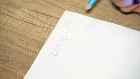 Close-up of woman's hand erases the writing on the paper covid - 19 Stock-Footage 128916366