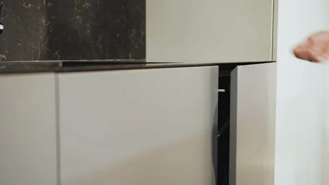 Close-up of woman's hand gently opens the kitchen bedside table. Empty kitchen Stock Footage 228989269