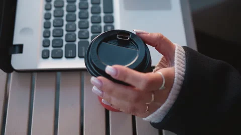 Close-Up of Woman's Hand Gently Turning Coffee Cup Near Laptop with Manicured Stock Footage 302905333