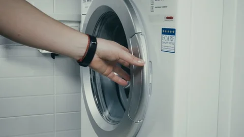 Close-up of the woman's hand to get the clothes in the washing machine. Stock Footage 101344377