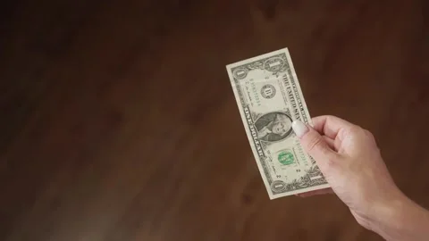 Close-up of a woman's hand gripping a single dollar bill Stock Footage 284845039