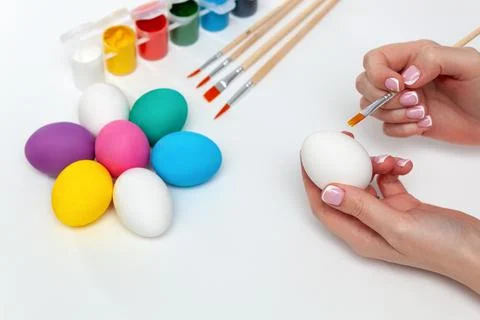 Close-up of a woman's hand holding a complex egg while painting. Stock Photos