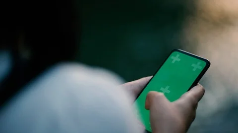 Close up of a woman's hand holding a mobile telephone with a vertical green Stock Footage 122590615