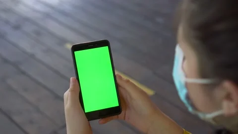 Close up of a woman's hand holding a mobile telephone with a vertical green Stock Footage 133026312