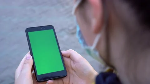 Close up of a woman's hand holding a mobile telephone with a vertical green Video stock 133683069