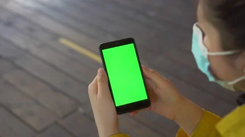 Close up of a woman's hand holding a mobile telephone with a vertical green Video stock 134305162