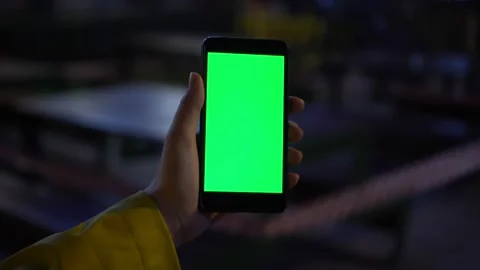 Close up of a woman's hand holding a mobile telephone with a vertical green Stock Footage 134716477