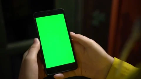 Close up of a woman's hand holding a mobile telephone with a vertical green Stock-Footage 134947857
