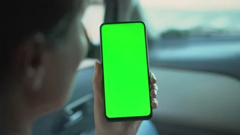 Close up of a woman's hand holding a mobile telephone with a vertical green Stock Footage 137984940