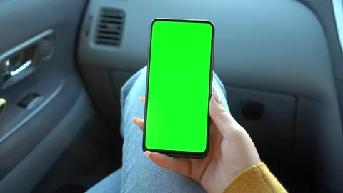 Close up of a woman's hand holding a mobile telephone with a vertical green Video stock 141204196