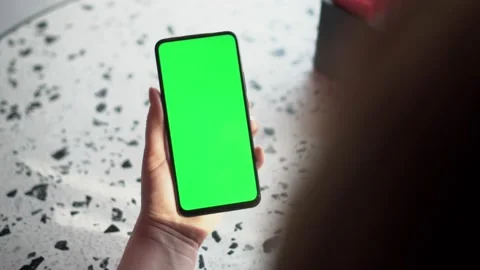 Close up of a woman's hand holding a mobile telephone with a vertical green Stock Footage 148619783