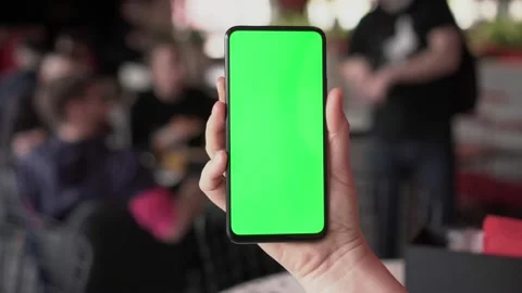 Close up of a woman's hand holding a mobile telephone with a vertical green Stock Footage 148633474