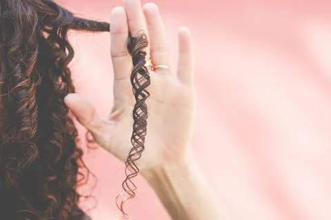 Close-Up of a woman's hand holding a ringlet of hair Stock Photos