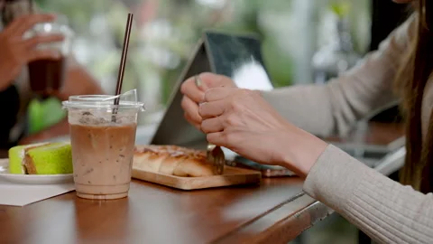 Close-up woman's hand holding small fork, cut bread in wooden tray Stock Footage 247370733