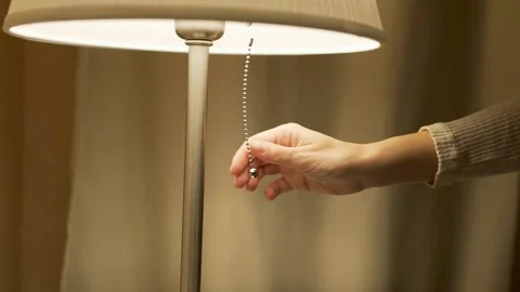 Close-up of a Woman's Hand, Including a Lamp. Turning on the Lamp in a Cozy Bedr Video stock 140971917