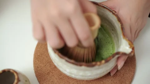 Close up woman's hand making traditional green tea matcha using bamboo natural. Stock Footage 338987981
